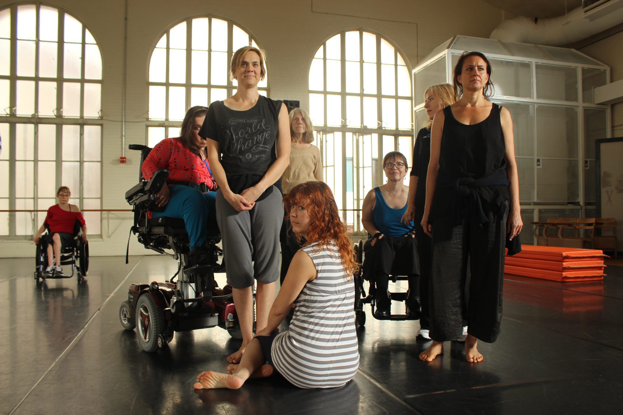 5 dancers with and without disabilities pose facing the camera.