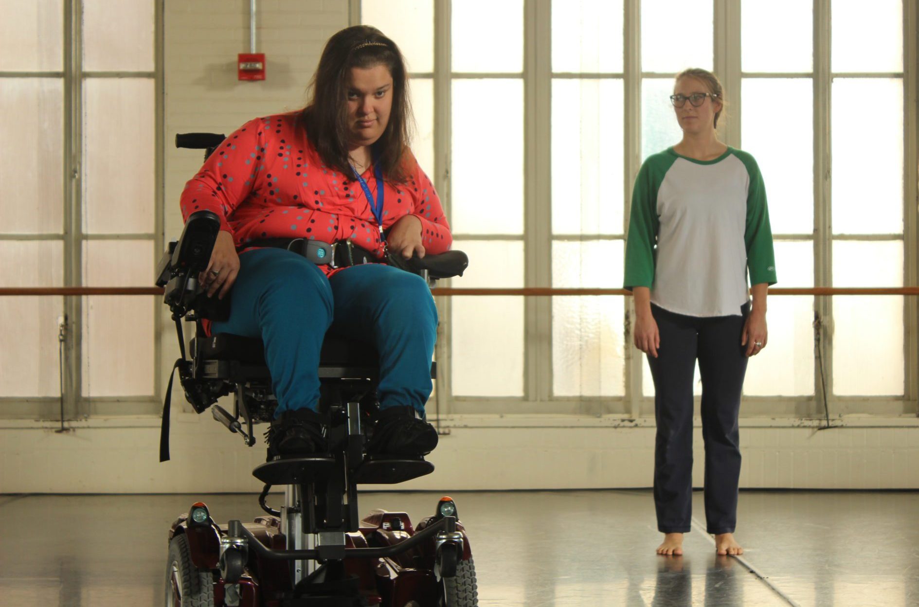 two dancers with and without disabilities face the camera.