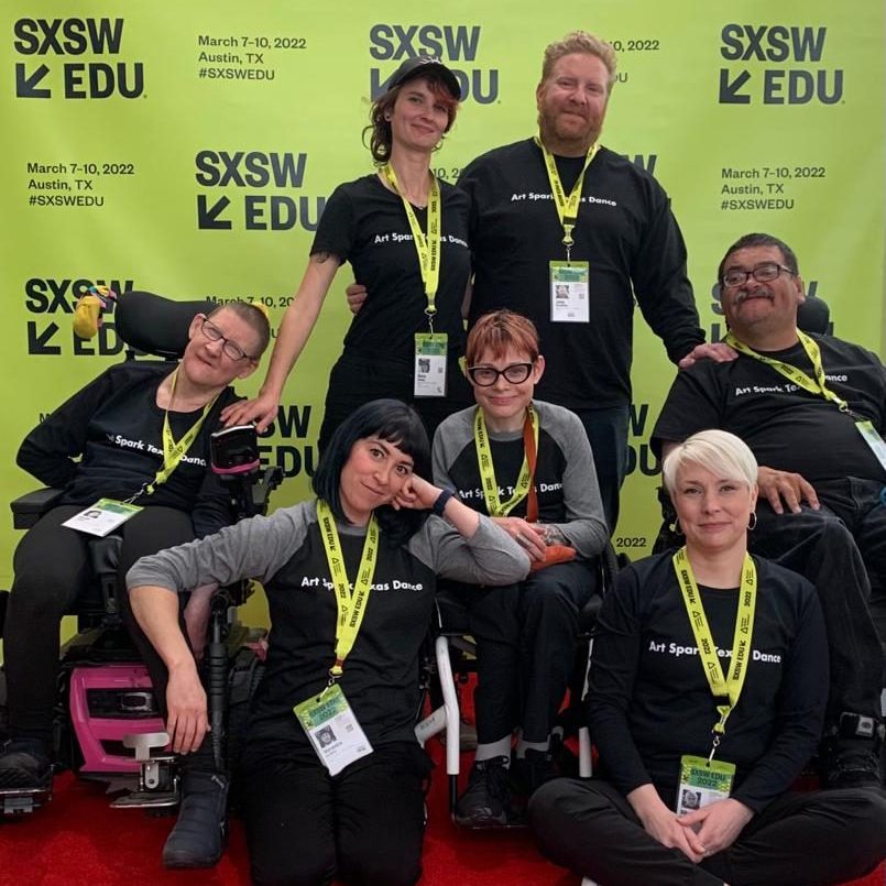 A group of art people pose on a red carpet at a SXSW event